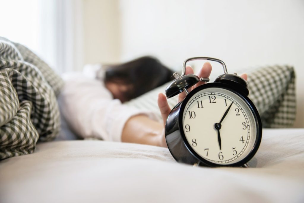 sleepy-woman-reaching-holding-the-alarm-clock-1024x684 Sen i jego znaczenie dla zdrowia 